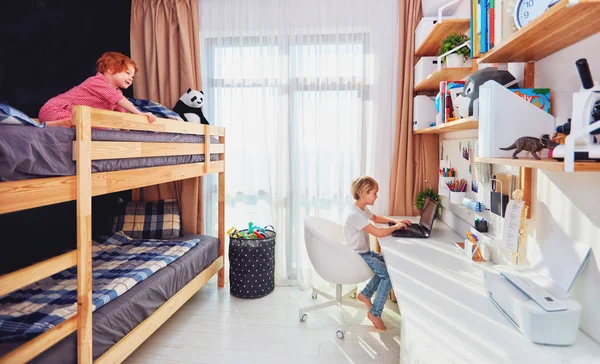 Two boys, brothers in kids room with bunk bed and wall shelves — Stock Photo, Image