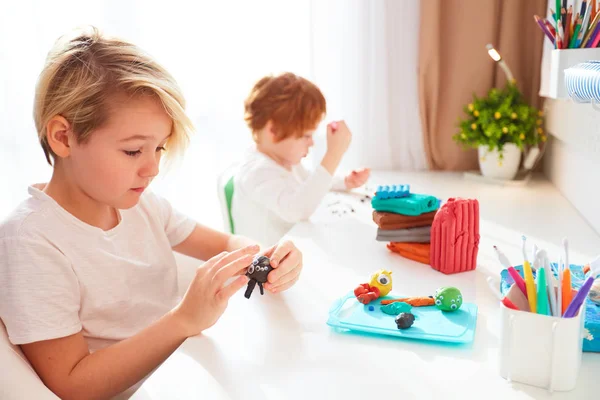 Leuke kinderen zijn het creëren van de hand ambachten van modelleren plasticine op kids kamer — Stockfoto