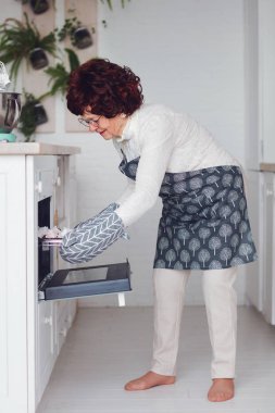 Mutlu zarif büyükanneler evdeki mutfakta yemek pişiriyor, aile yemeği için son hazırlıklar.