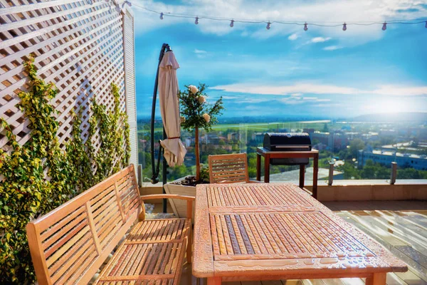 Muebles de madera cubiertos con gotas de agua después de la lluvia caliente de primavera en el patio de la azotea — Foto de Stock