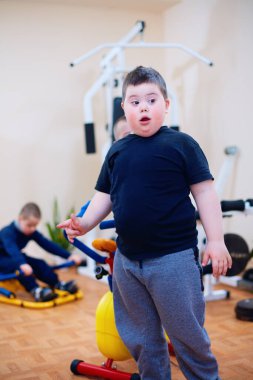 Özel ihtiyaçları olan çocuklar için kapsayıcı spor merkezinde Down sendromlu şirin bir çocuk. Dolu dolu bir hayat