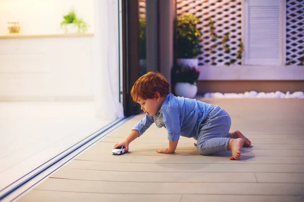Bebe Garcon Tout Petit Mignon Jouant Avec Voiture Jouet Au Patio Avec Cuisine Ouverte Et Portes Coulissantes Domestiques Crepuscule Stock Photo