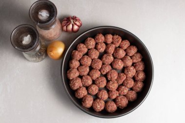 Çiğ kıymalı köfteler, temiz arka planda pişirme konseptini hazırlamaya hazır.