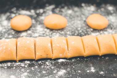 Sarı hamuru mısır ekmeğine dönüştürerek siyah masa üzerinde biraz un ile. Ev yapımı sağlıklı ekmek düzlüğü.. 