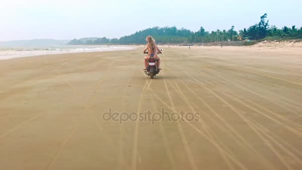 Pary jazda konna motocykl na plaży w pobliżu wody — Wideo stockowe