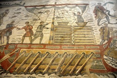 Antik Roma mozaik sahnesinde Afrika 'dan Roma' ya taşınmak üzere bir Afrika Sanga Sığır Boğası 'nın bir kadırgaya (Acatus) bindirildiği görülüyor. UNESCO listesinden Villa Romana del Casale, Sicilya