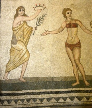 Antik Roma mozaiğinde bikinili bir kız bir oyun kazandı, bir gül tacı ve toga giymiş bir bayandan yaprak aldı. UNESCO listesinden Villa Romana del Casale, Sicilya