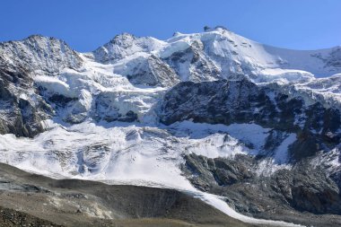 Zinalrothorn (sağda), Blanc de Moming ve Schallihorn (solda) İsviçre Alpleri 'ndeki Zinal tatil beldesinin tepesinde.