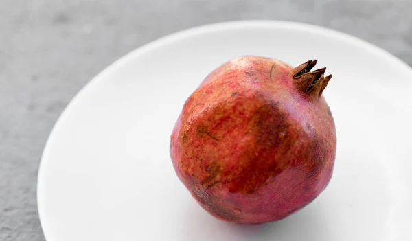 Jedno Celé Červené Zralé Čerstvé Syrové Granátové Jablko Bílém Talíři — Stock fotografie