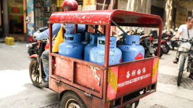 Macau Adası, Macau - 30 Nisan 2017: Asya sokakları, bir sürücü, evlere ve vatandaşlara gaz silindirleri taşıyor, hafif odaklı, hareket halinde bulanık