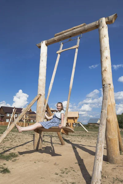 Дівчина гойдається на дерев'яній рисі — стокове фото