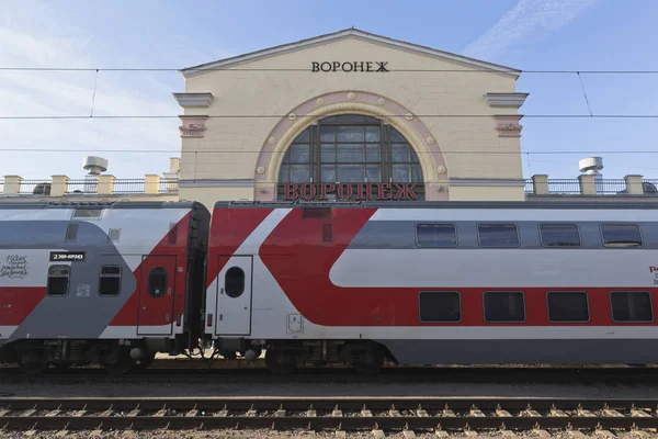 Брендированный двухэтажный поезд на фоне железнодорожного вокзала в Воронеже — стоковое фото