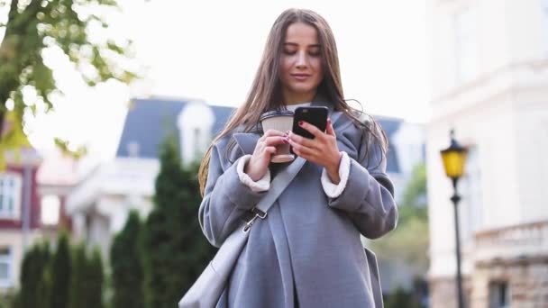 Mujer joven enviando mensajes de texto o usando teléfono inteligente — Vídeo de stock