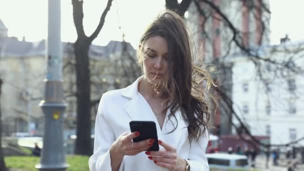 Femme Séduisante Tapant Des Messages Sur Son Smartphone Tout Ayant — Video