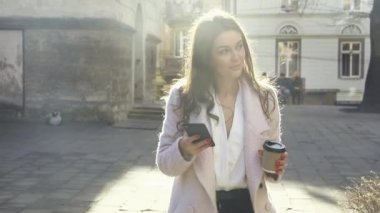 Sokakta dikilirken akıllı telefonuna mesajlar yazan çekici bir kadın. Dışarıda eğlenmek ve eğlenmek. Kameranın önünde akıllı telefonlu güzel bir esmer. Güzel kız.