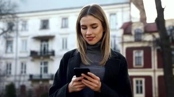 Mujer Atractiva Escribiendo Mensajes Smartphone Mientras Pasea Por Calle Divertirse — Vídeos de Stock