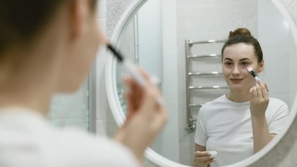 Young Pretty Woman Applies Face Cream Her Cheekbones Looks Mirror — Stock Video