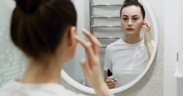 快乐迷人的年轻女子在用完油后摸着漂亮的脸蛋化妆照镜子 享受自然美和健康清洁 保湿的肌肤护理治疗 近距离观察 — 图库视频影像