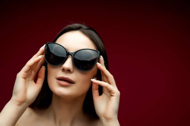 Kalp şeklinde güneş gözlüklü güzel bir kadının portresi. Parlak arka planda poz veren kapüşonlu güzel kız. Metin için boş alan.