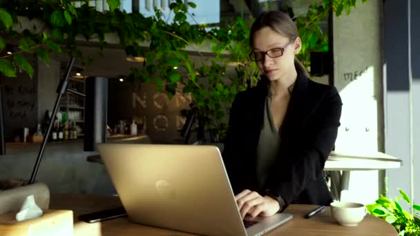 Konzentrierte Geschäftsfrau Mit Stylischer Brille Sitzt Café Und Arbeitet Laptop — Stockvideo