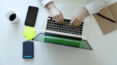 Kadın elleri klavye bilgisayarında daktilo kullanıyor. Üst görünüm. Modern akıllı telefon. Sanat masasında çalışıyor.