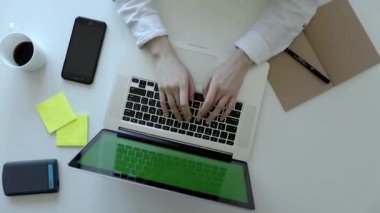 Kadın elleri klavye bilgisayarında daktilo kullanıyor. Üst görünüm. Modern akıllı telefon. Sanat masasında çalışıyor.