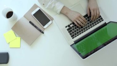 Kadın elleri klavye bilgisayarında daktilo kullanıyor. Üst görünüm. Modern akıllı telefon. Sanat masasında çalışıyor.