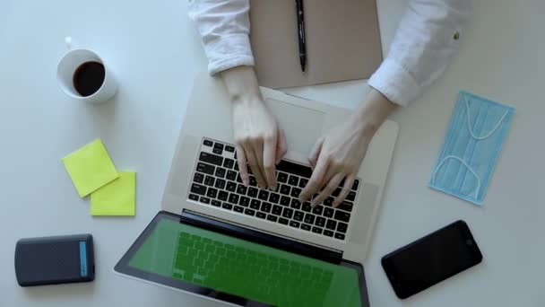 女性的手在键盘笔记本电脑上打字特写镜头俯瞰现代智能手机工作空间办公桌互联网搜索在线商务创意写作自由职业者阳光 — 图库视频影像