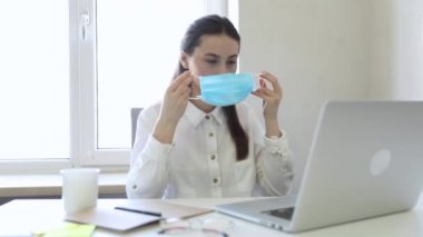 25-26 yaşlarındaki Avrupalı iş kadınları PM2.5 ve virüsü korumak için ofiste çalışırken koruyucu maske takıyorlar. Sağlık ve Koruma Konsepti.