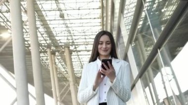 Sokakta telefonu kullanan başarılı bir iş kadını. Ciddi bir iş kadını dışarıda telefonla dolaşıyor. Sokakta telefonda seksi kadın mesajlaşması. Akıllı telefon ile çalışan kadın girişimci.