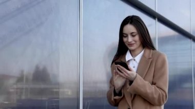 Sokakta telefonu kullanan başarılı bir iş kadını. Ciddi bir iş kadını dışarıda telefonla dolaşıyor. Sokakta telefonda seksi kadın mesajlaşması. Akıllı telefon ile çalışan kadın girişimci.