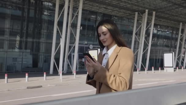 在街上用电话接近成功的女商人 一个严肃的女商人带着电话走在户外 性感女人在街上用电话发短信 使用智能手机的女企业家 — 图库视频影像