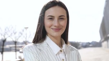 Modern iş merkezinde çalışırken kameraya bakan mutlu iş kadını, yavaş çekim.