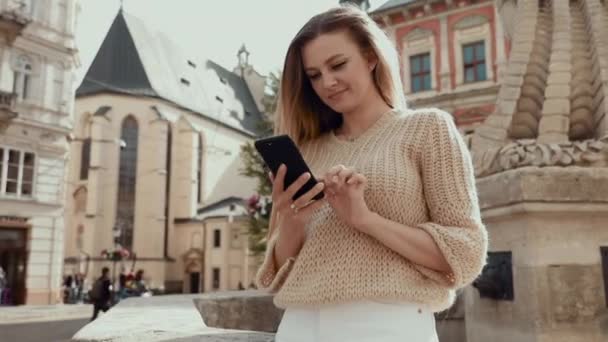 Erfarna kvinnliga advokat med läder portfölj sitter på allmän urbana med modern mobiltelefon enhet i handen och göra online bokning under biljettförsäljning på webbplatsen med affärsflyg — Stockvideo