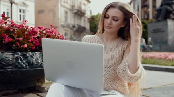 Pretty młoda kobieta biznesu pracuje na laptopie podczas siedzenia na zewnątrz na schodach — Wideo stockowe