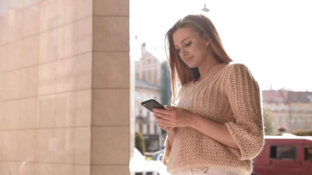 Młoda kobieta w mieście smsuje przez komórkę. — Wideo stockowe
