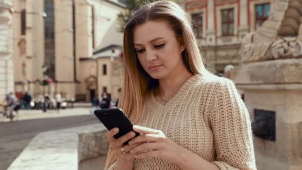 Jonge vrouw in de stad sms 'en mobiele telefoon — Stockvideo