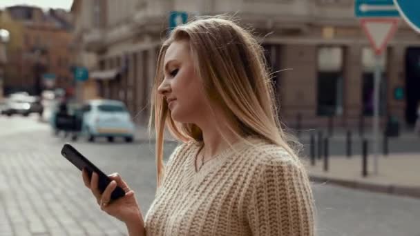 Hermosa Mujer Con Encantadora Sonrisa Caminando Por Calle Usando Teléfono — Vídeo de stock