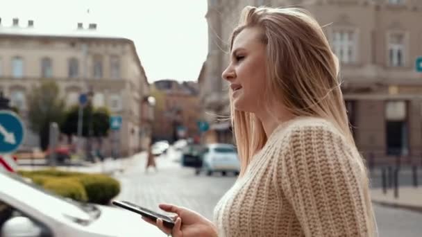 美丽的女人 带着迷人的微笑在街上散步 用手机 戴着现代太阳镜 穿着时髦的衣服 衣冠楚楚的年轻迷人女人 — 图库视频影像