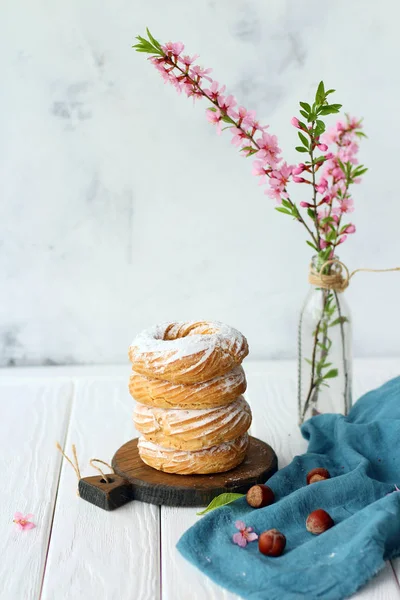 Sammansättningen av en flaska, dessert och blommande mandel på vit bakgrund Stockbild