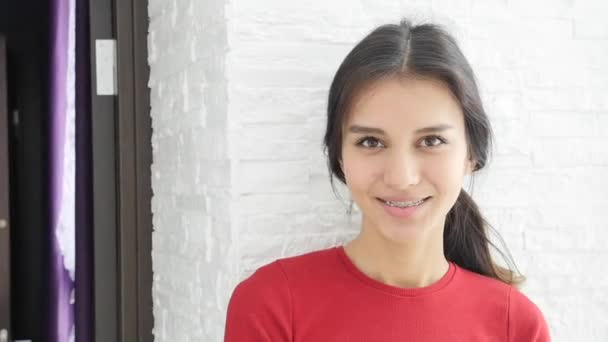 Girl with braces. Young beautiful girl smiles and does not hesitate to show off her braces — Stock Video