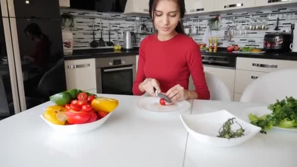 Jeune femme caucasienne cuisine salade de légumes . — Video