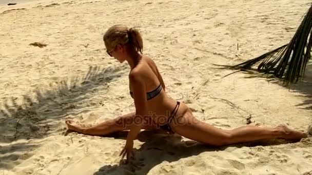 Девушка сидит на веревке на пляже — стоковое видео