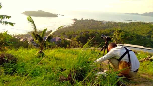 Fotografer mengambil digital SLR kamera matahari terbit di atas laut — Stok Video