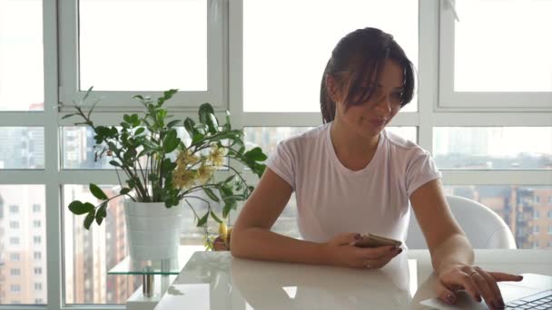 Caucasian girl in white t-shirt using a smartphone — Stock Video