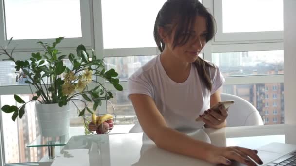 Chica caucásica en camiseta blanca usando un teléfono inteligente — Vídeo de stock