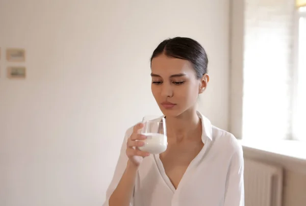 Mujer joven bebiendo yogur Imagen de archivo