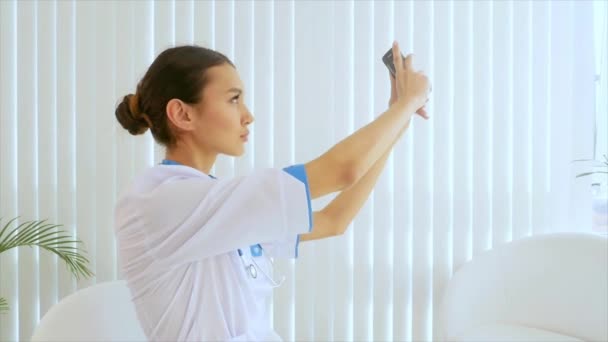 Joven atractiva doctora haciendo selfie con un teléfono móvil — Vídeo de stock