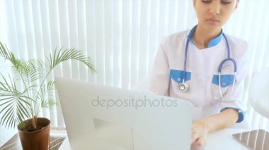 Doktor tıbbi bir elbise giyiyor, bir stetoskop boynunda asılı.