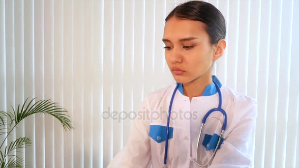 Ο γιατρός φορώντας ένα ιατρικό φόρεμα, ένα στηθοσκόπιο κρεμασμένο στο λαιμό. — Αρχείο Βίντεο
